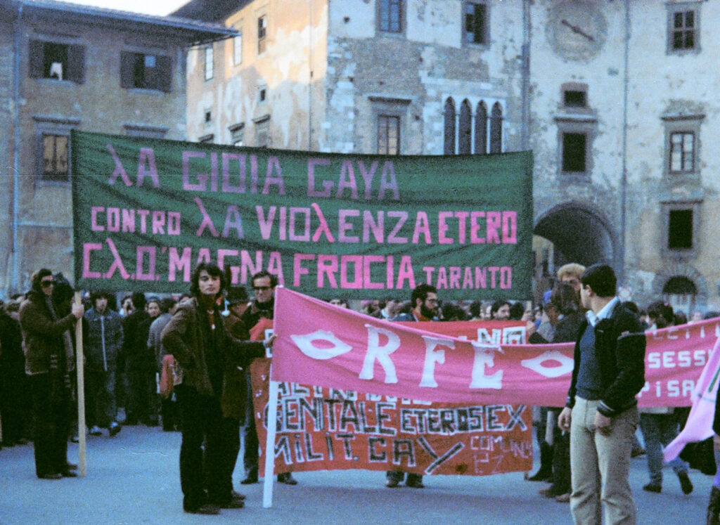 Primo Pride a Pisa nel 1979, con grandi striscioni contro la violenza etero e per il femminismo e la sessualità.